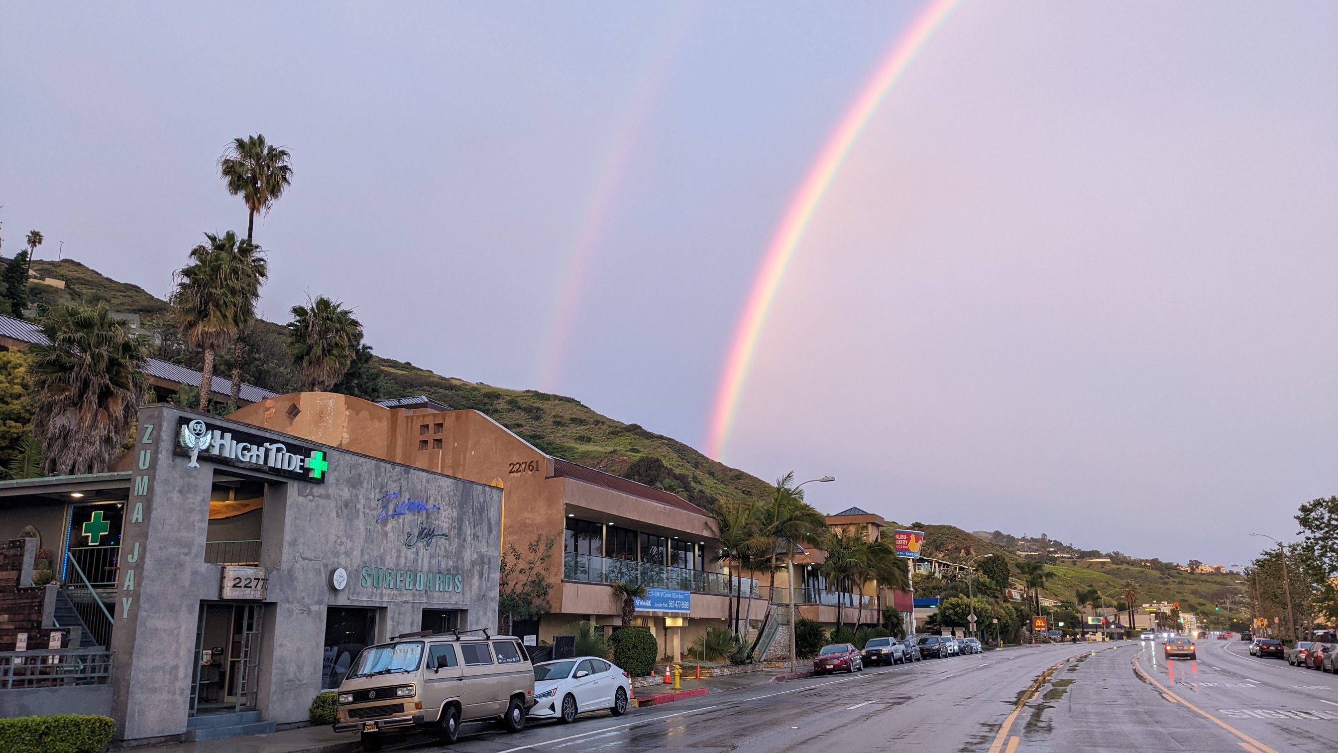 The exterior of (( High Tide Dispensary in Malibu with a rainbow over the cannabis shop